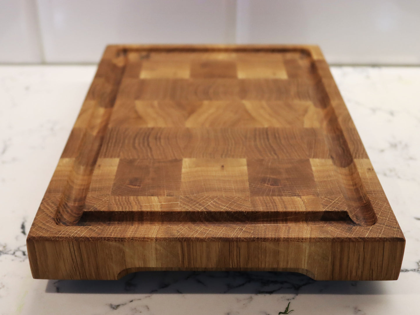 Exclusive end grain cutting board with a juice groove